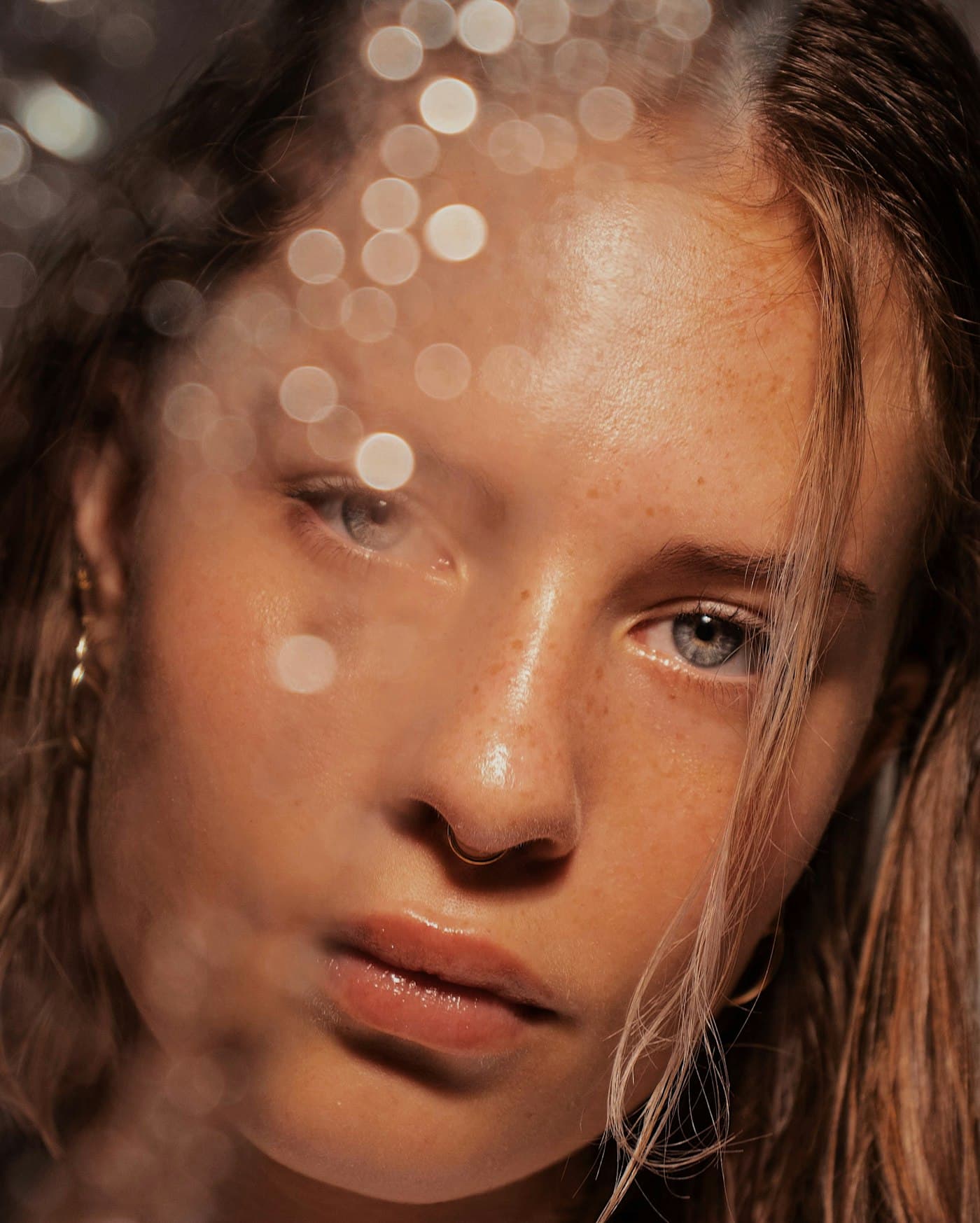 Editorial close-up of a model with dewy, glowing skin